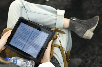 A model reads a book using an electronic device before the Lacoste Spring 2011 collection during New York Fashion Week